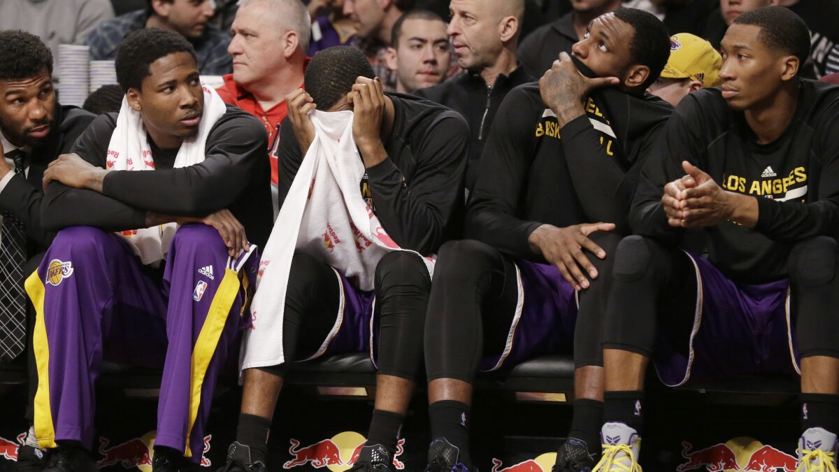 Lakers players , including Ed Davis at left, on the bench react to a call during a 107-99 road loss to the Brooklyn Nets on March 29, 2015.