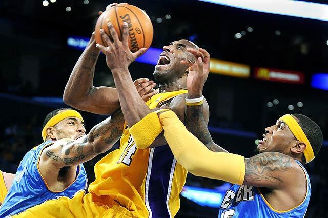 Lakers Kobe Bryant is fouled by Nuggets Kenyon Martin, left, as Carmelo Anthony helps on the play in Game 2 of the Western Conference Finals at the Staples Center.