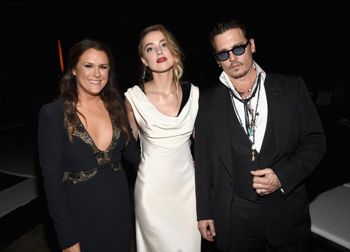 Art of Elysium founder Jennifer Howell, left, with honoree Amber Heard and Johnny Depp at the organization's gala Jan. 10.