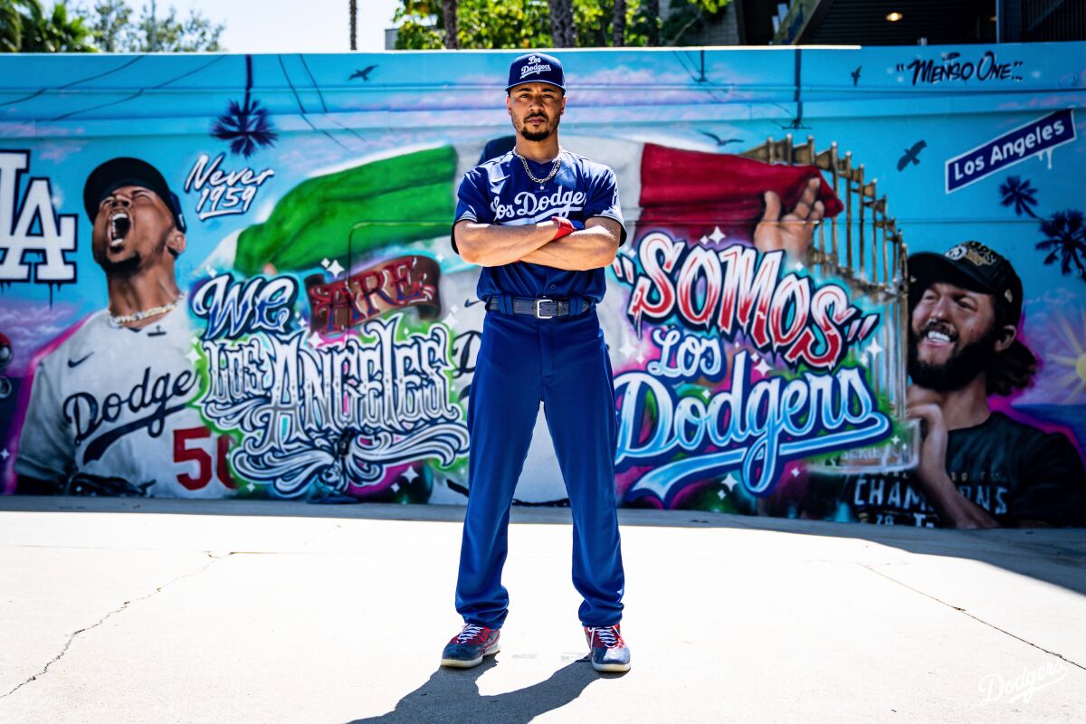 Dodgers' Mookie Betts poses in front of street art.