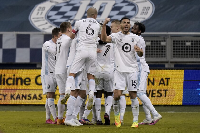 Minnesota United players celebrate after a goal by Bakaye Dibassy during the first half of an MLS soccer match against Sporting Kansas City on Thursday, Dec. 3, 2020, Kansas City, Kan. (AP Photo/Charlie Riedel)