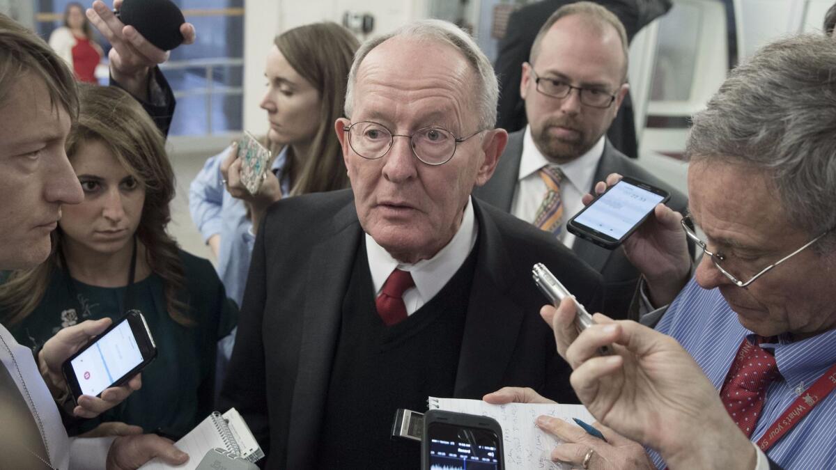 Republican Sen. Lamar Alexander talks to reporters on Oct. 19. His bipartisan compromise on Obamacare with Democratic Sen. Patty Murray is still awaiting a vote.