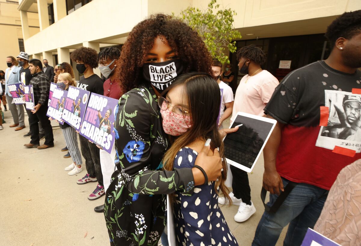 Tianna Arata, left, hugs friend Nicole Huffman before Tuesday's rally.