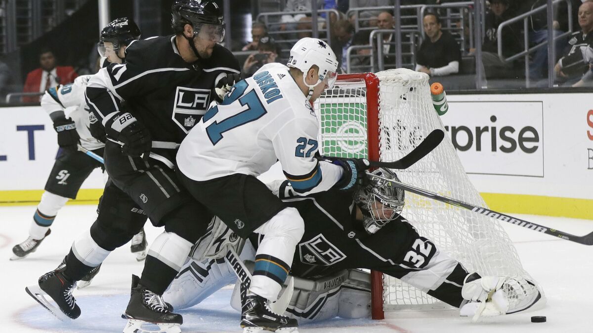 Kings' Jonathan Quick, right, stops a shot next to San Jose Sharks' Joonas Donskoi (27) during the first period on Friday at Staples Center.
