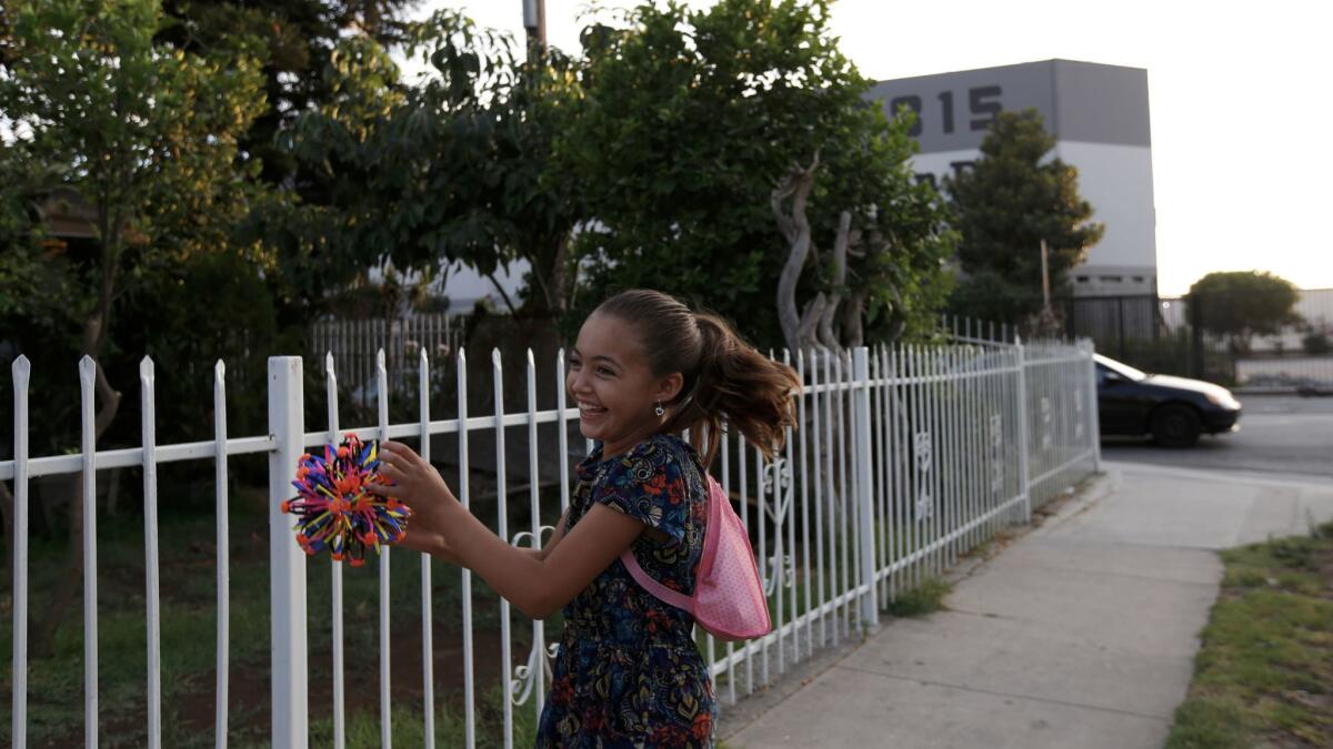 Bella Marquez, 8, plays catch across the street from Maywood L’Chaim, the second business that was approved for licenses to cultivate, manufacture and dispense marijuana.