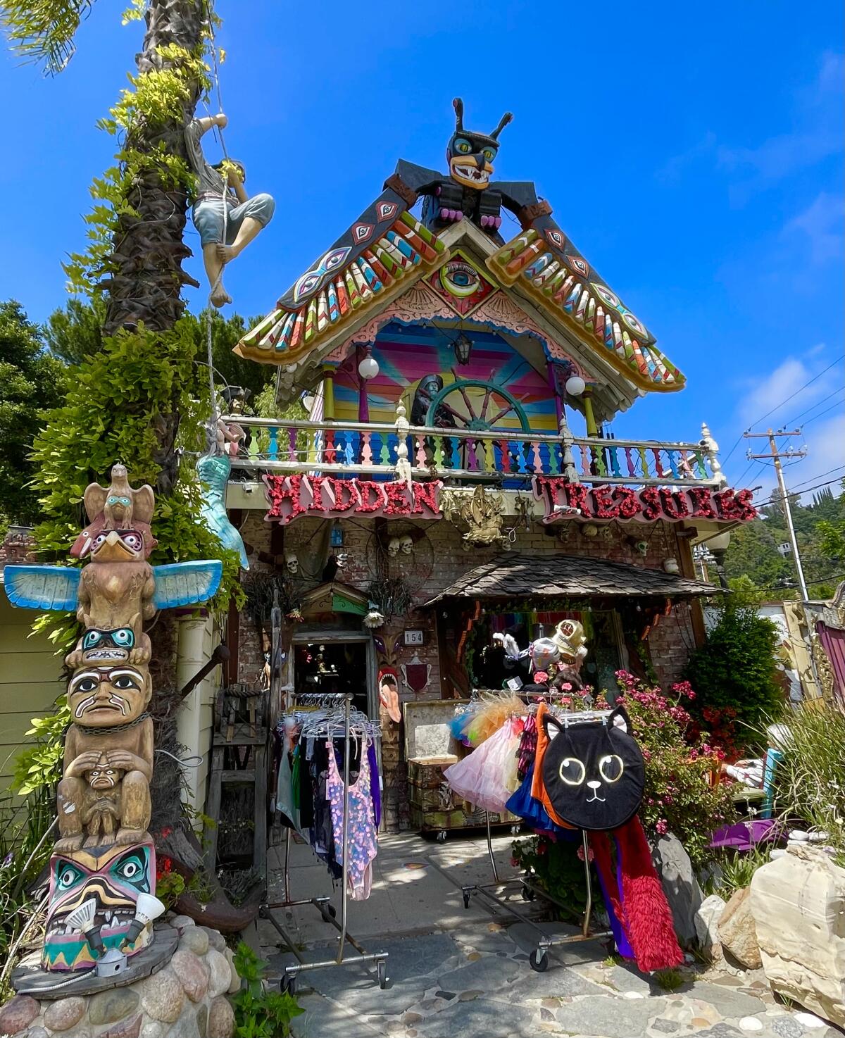 A kitschy storefront with a totem pole and colorful decorations.