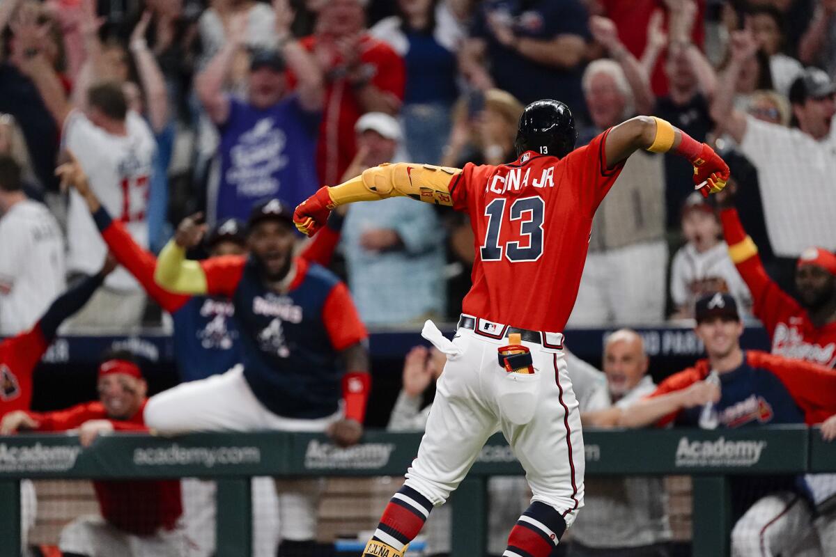 Atlanta Braves' Ronald Acuna Jr. (13) and teammates celebrate his two-run home against the Philadelphia Phillies during the eighth inning of a baseball game Friday, Sept. 16, 2022, in Atlanta. (AP Photo/John Bazemore)