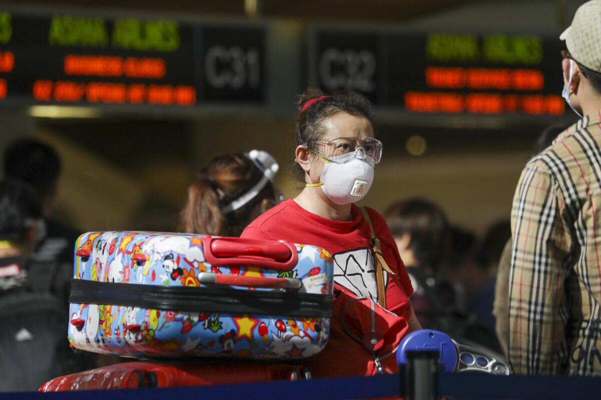 An LAX passenger, mask in place, lines up on May 22.