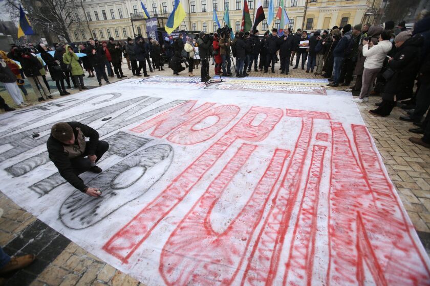 KIEV, UKRAINE - JANUARY 9: A protester draws a poster with the words "Say no to Putin" durign a rally "Say no to Putin" in Kiev, Ukraine on January 9, 2021. Ukrainian nationalists are displeased with the interference of Russian President Vladimir Putin in the internal affairs of Kazakhstan. Russia sent about 3,000 troops to Kazakhstan to quell protests. (Photo by Stringer/Anadolu Agency via Getty Images)