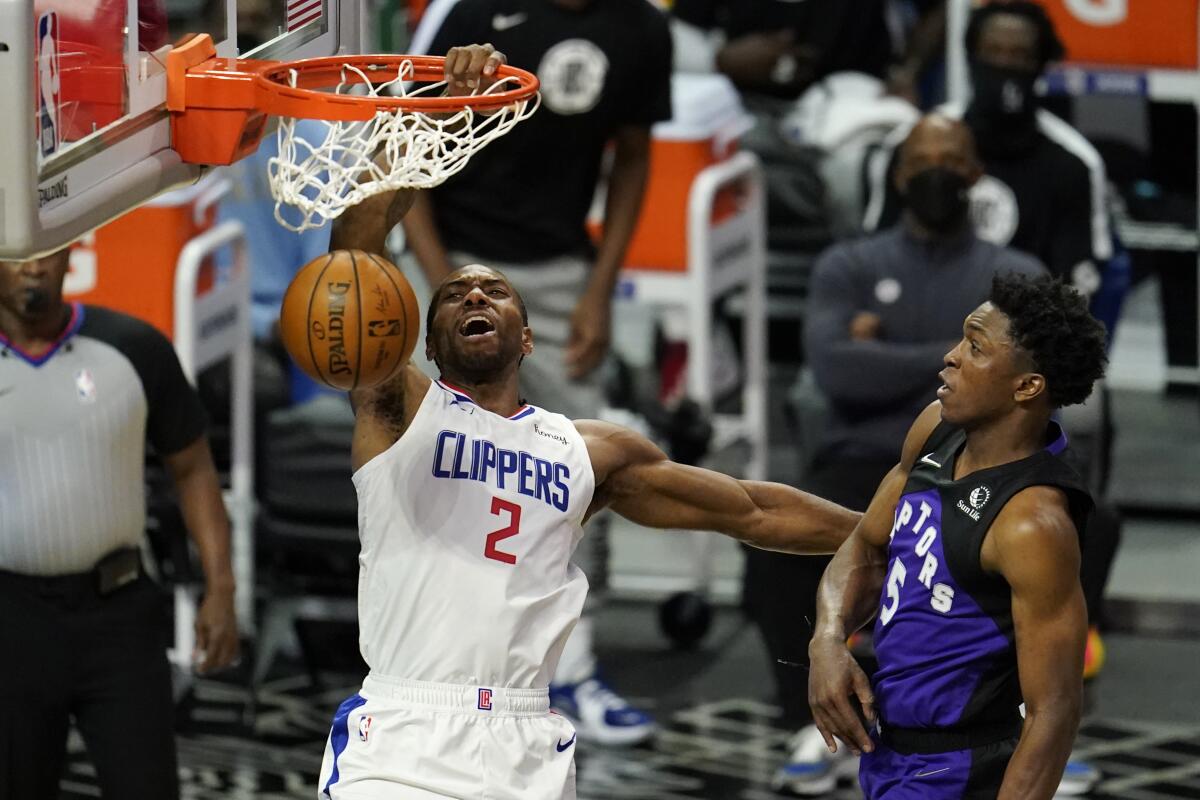 Clippers forward Kawhi Leonard dunks past Toronto Raptors forward Stanley Johnson.