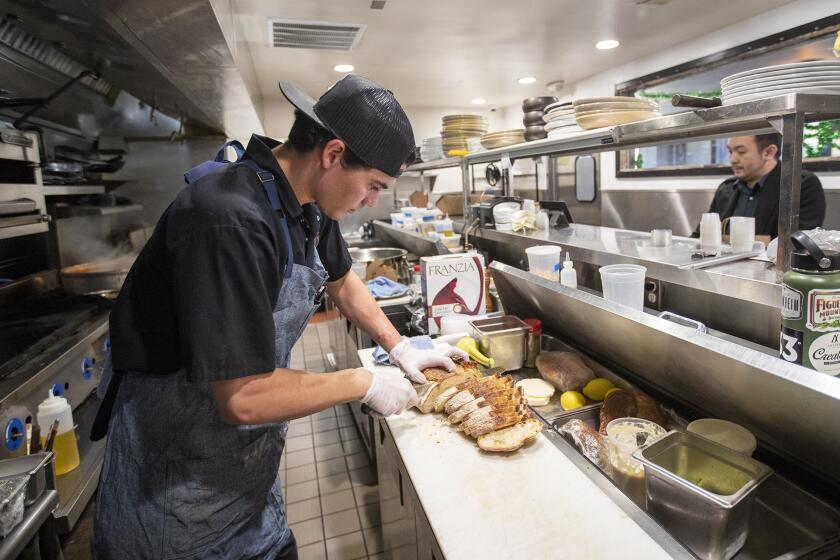 Grant Harris, the executive chef of The Recess Room in Fountain Valley, prepares grab and go lunches on Friday, March 27. The restaurant is giving free lunches on Fridays to seniors ages 65 and older and to students up to 18.