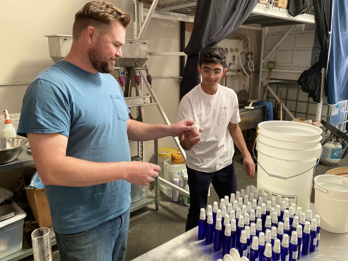 Pacific Ridge student Sid Israni and his chemistry teacher Justin McCabe are producing and bottling hand sanitizer for donation to community organizations.