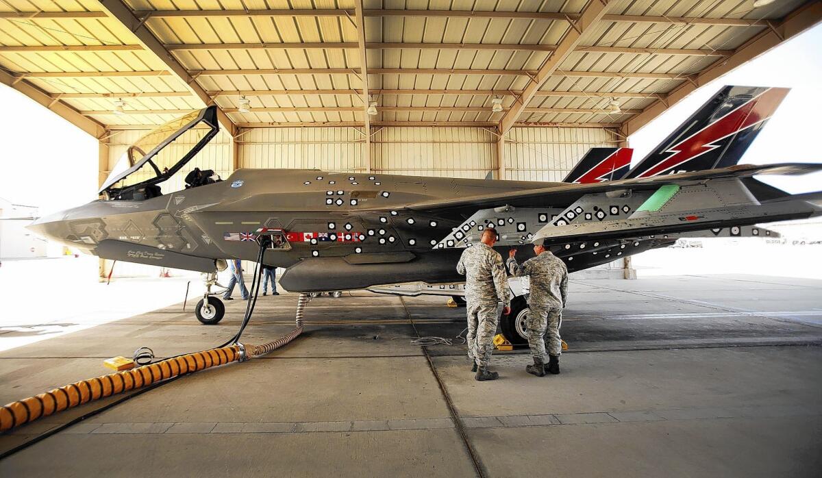 A Lockheed Martin F-35 Joint Strike Fighter is prepared for flight during testing at Edwards Air Force Base in March 2013. The numerous decals fixed to the side of the jet are used to monitor flight and payload performance by video.