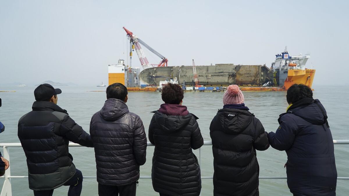 Families of missing victims participated in an emotional memorial service near the transport vessel carrying the ferry Sewol near Jindo, South Korea, on Tuesday.