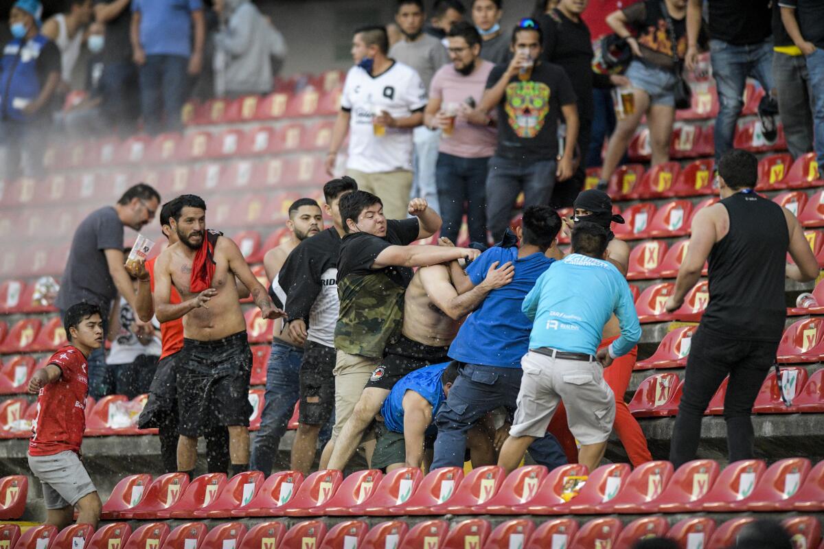 Fans clash in the stands during a Mexican soccer league match