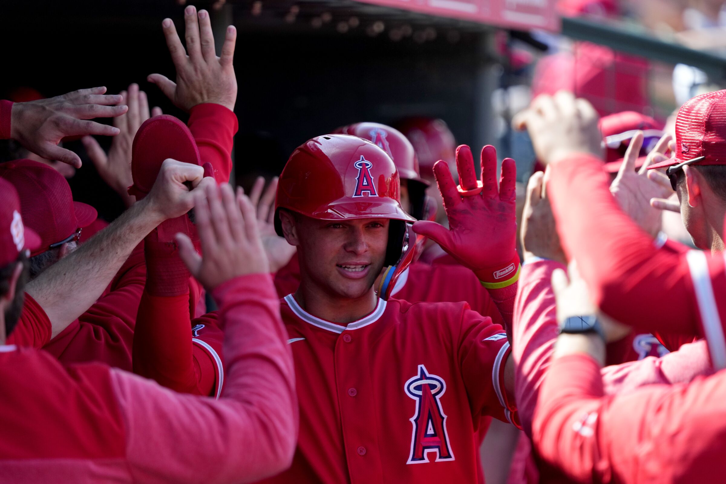 The Angels' Logan O'Hoppe high-fives teammates after scoring on a base hit by Andrew Velazquez.