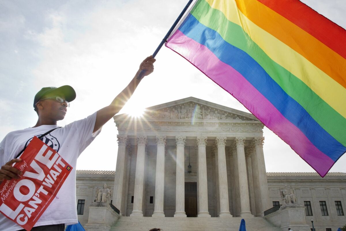 A supporter of same-sex marriage waves a flag outside the U.S. Supreme Court.