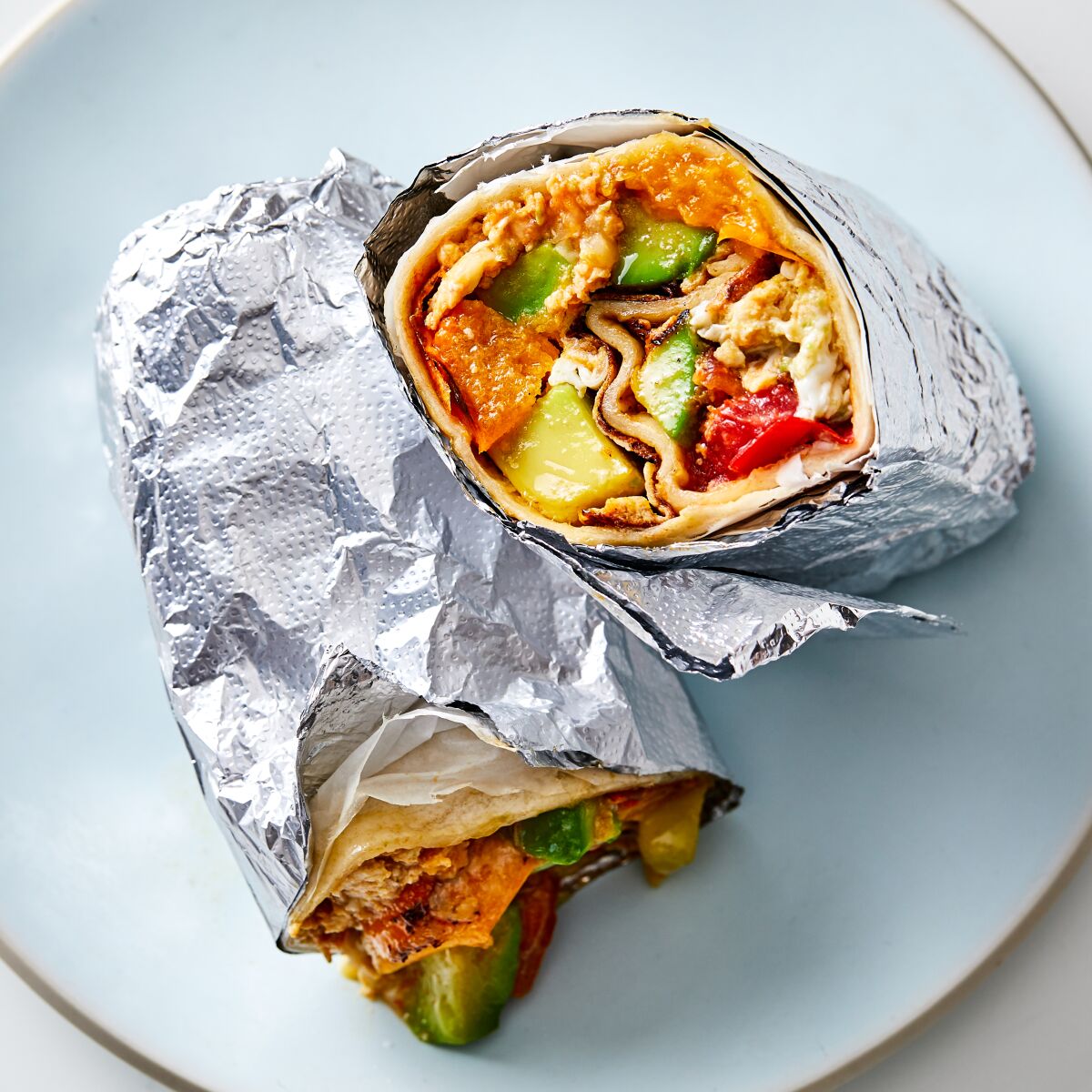 Overhead shot of a breakfast burrito wrapped in foil 