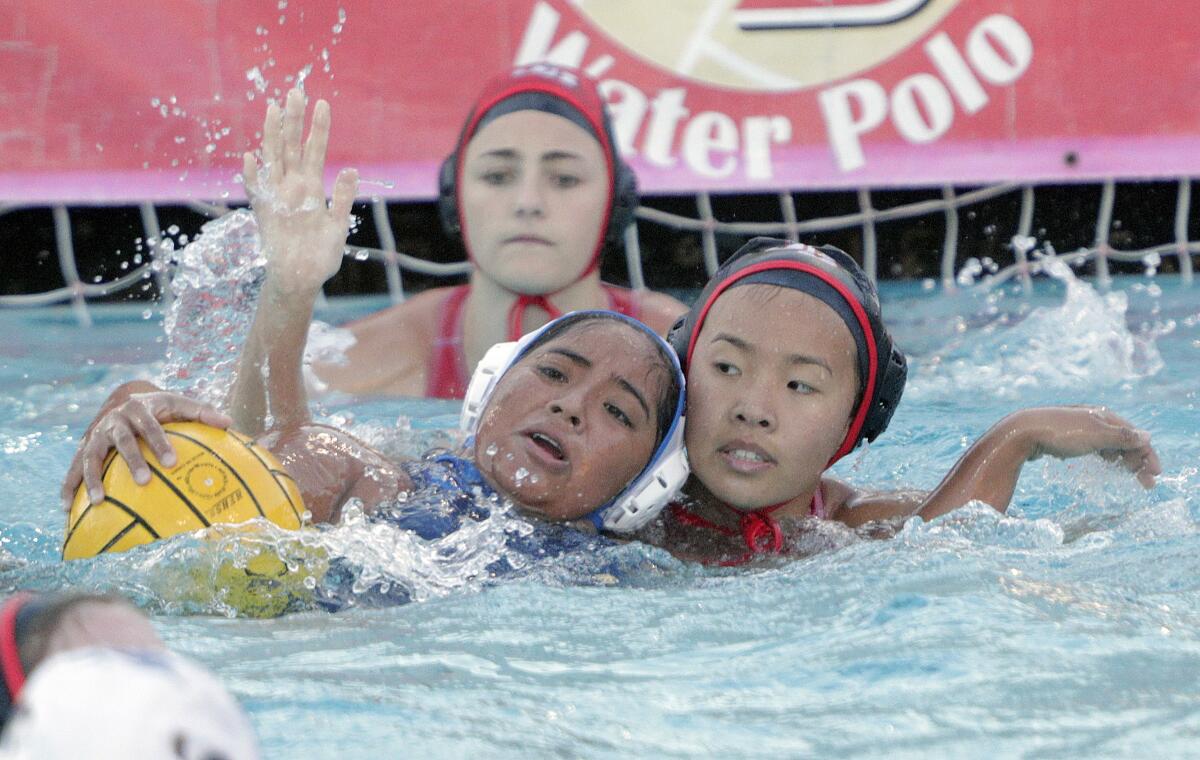 Santa Ana's Monique Caridad battles for position to shoot with Burroughs' Angelina Lee defending in the first round of the CIF Southern Section Division V girls' water polo playoffs at Burroughs High School on Tuesday, February 11, 2020. Burroughs won the game and advances.