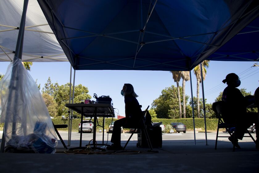 MORENO VALLEY, CA - SEPTEMBER 22, 2021: Nurses wait in the parking lot under tents for residents to arrive for vaccinations, but they only administered 31 shots in 5 hours at this vaccination site at Quinn Community Outreach on September 22, 2021 in Moreno Valley, California. A Los Angeles Times analysis found counties in the Inland Empire had a higher rate of hospitalizations this past summer than any other Southern California county.(Gina Ferazzi / Los Angeles Times)