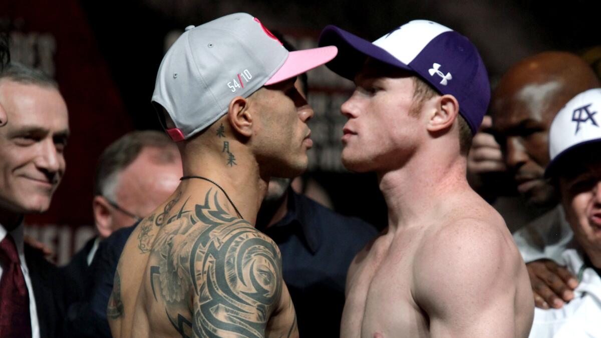 Miguel Cotto, left, and Saul "Canelo" Alvarez face off after their weigh-in Friday in Las Vegas.