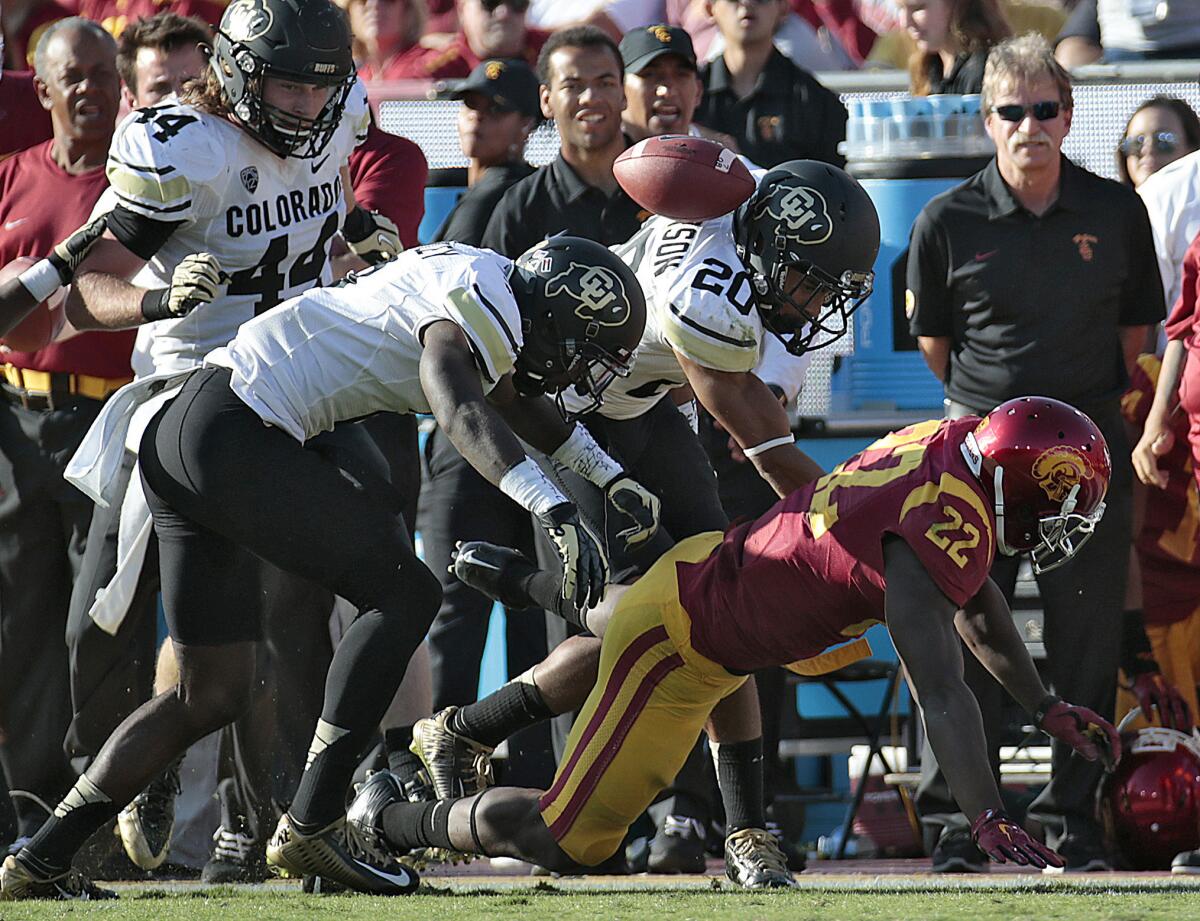 USC tailback Justin Davis fumbles after a long run against Colorado at the Coliseum.