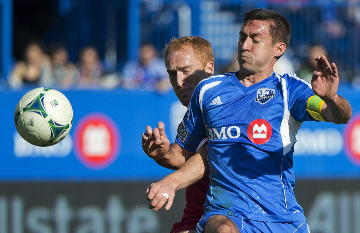 Montreal Impact captain Davy Arnaud, right, battles for the ball with the Chicago Fire's Jeff Larentowicz during first half of an MLS game earlier this season.