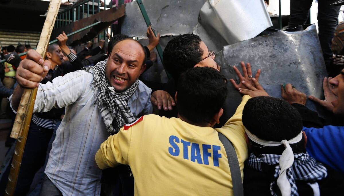 Protesters dismantle a barrier at the presidential palace in Cairo.