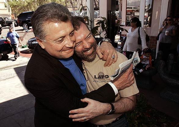 City attorney candidate Carmen Trutanich, left, hugs Paul Waters, executive director of Los Angeles Valley Pride, at Studio City Hand Car Wash on Tuesday. The car wash offered free washes to people who could prove they went to the polls to vote earlier in the day.