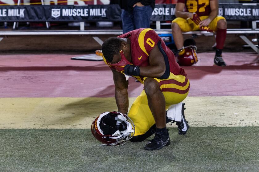 USC running back MarShawn Lloyd kneels and covers his face with his hand after losing 34-32 to Utah 