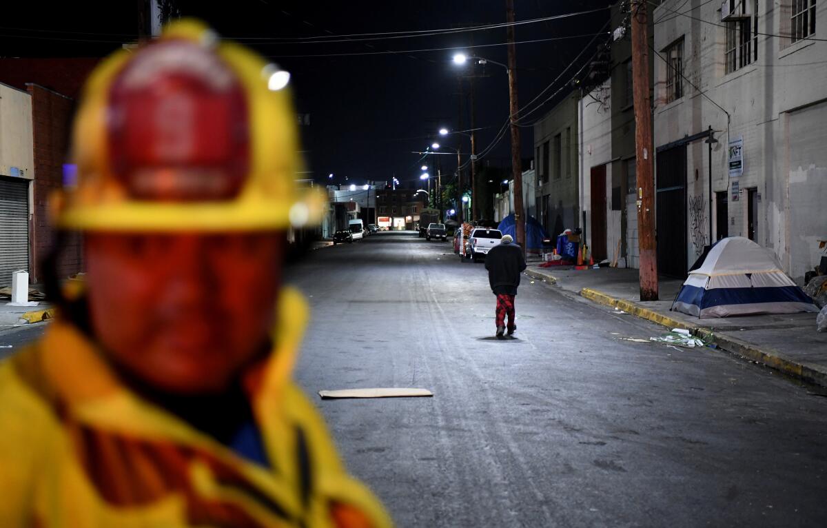 Station No. 9 firefighter Tony Navarro looks on as a homeless woman walks by during a training session
