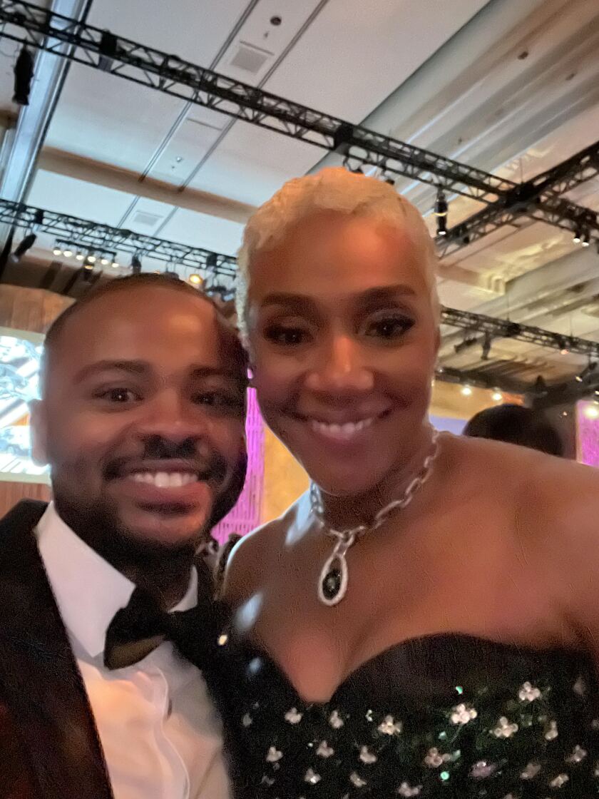 A man and a woman in formal wear pose for a photo.