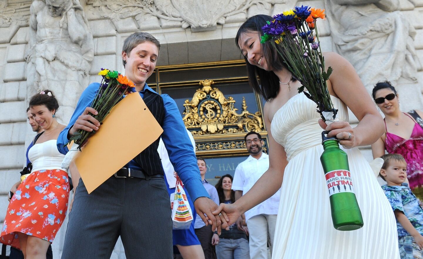 Newlyweds Carey Myslewski, left, and Katy Yan walk out of City Hall on Saturday.