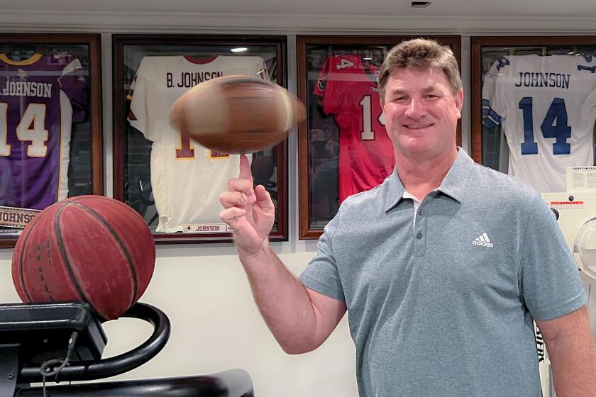 Super Bowl-winning quarterback Brad Johnson spins a football on his finger inside his Athens, Ga., home.