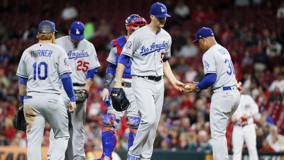 Dodgers starting pitcher Alex Wood, center, is taken out of the game in the fourth inning against the Cincinnati Reds.