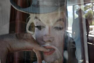 Schaben, Allen J. –– – LAKE TAHOE, NEVADA – May 22, 2009: Tour guide Carl Buehler is reflected in a photo of Marilyn Monroe hanging in cottage @@#3 at the historic Cal Neva Resort, Spa and Casino once owned by Frank Sinatra, which she frequented and was reported to have overdosed in shortly before her death in Brentwood, California. The Cal Neva was up for auction and nobody wanted it. It fell into foreclosure after its most recent ex–owner was forced into bankruptcy by members of L.A.'s Persian Jewish community. Cal Neva managert Bob Marcil is working hard to bring in new talent and show off the underground tunnels that Sinatra used to hustle mobsters and celebs around the place, the showroom he built, Marilyn Monroe's cottage, etc.. (Allen J. Schaben/Los Angeles Times)