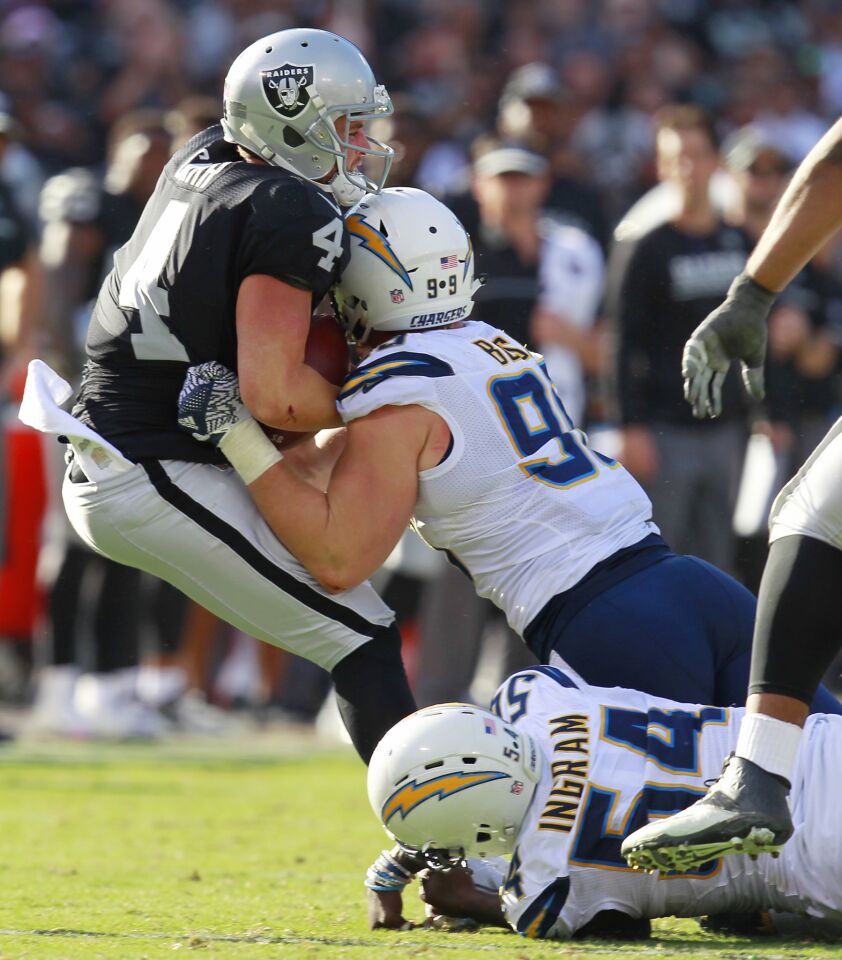 San Diego Chargers Joey Bosa (99) sacks Raiders quarterback Derek Carr in the 4th quarter in Oakland on Oct. 9, 2016. (Photo by K.C. Alfred/The San Diego Union-Tribune)