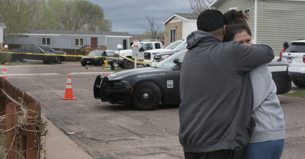 A man and a woman hug near the scene of a mass shooting.