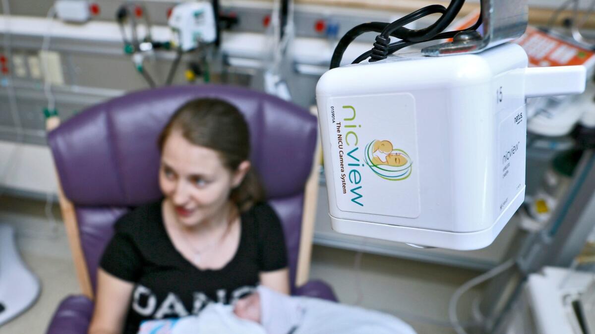 Katerina Wilson, of Burbank, sits with her 34-week-old son Connor and a NICVIEW streaming camera system above her, at the neonatal intensive care unit department, Providence St. Joseph Medical Center, in Burbank on Thursday, June 1, 2017.