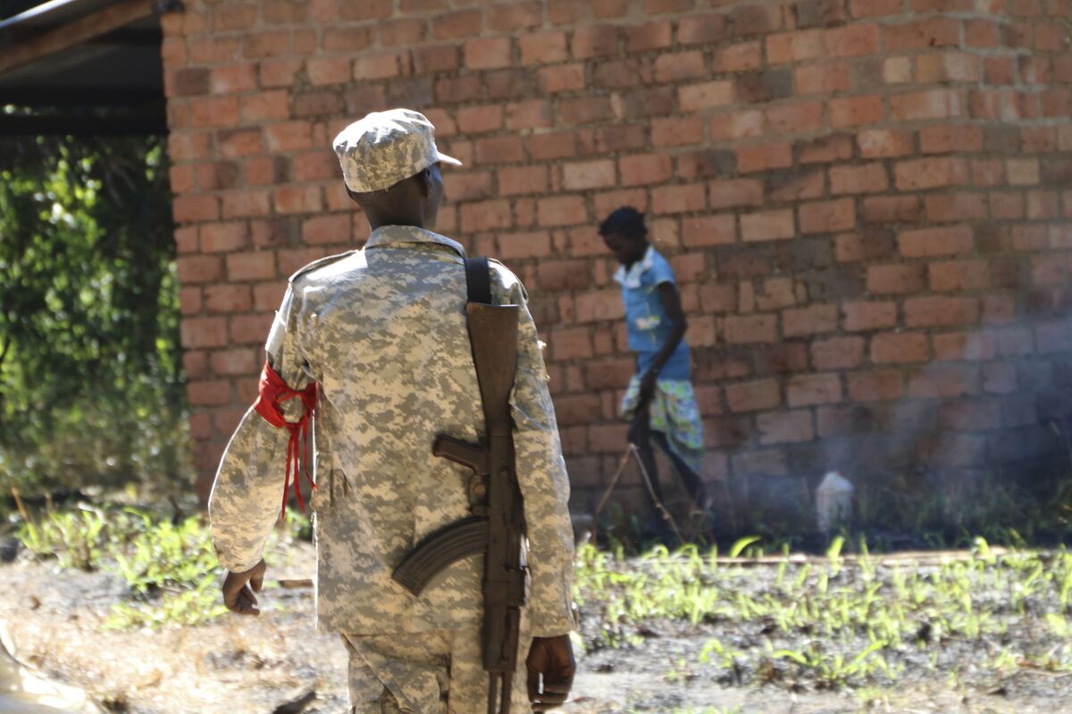 A soldier walks through a market outside of Yei town in Central Equatoria state, Wednesday, Dec. 23, 2020. Ten years after South Sudan gained its independence and two years after its own deadly civil war ended, large-scale fighting has subsided but clashes continue between communities and between the government and groups that did not sign the peace deal — and the use of rape as a weapon remains rampant. (AP Photo/Sam Mednick)