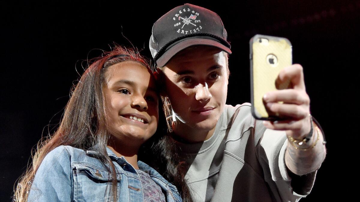 Justin Bieber takes a selfie with a fan onstage during his Nov. 13, 2015, show at Staples Center.