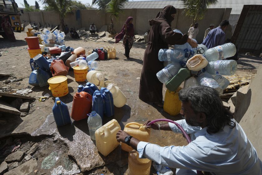 Gente recogiendo agua de un punto de suministro en una barriada de Karachi, Pakistán, el martes 21 de marzo de 2023. El 22 de marzo se celebra el Día Mundial del Agua, para recalcar la importancia del agua dulce y defender la gestión sostenible de ese recurso vital. (AP Foto/Fareed Khan)