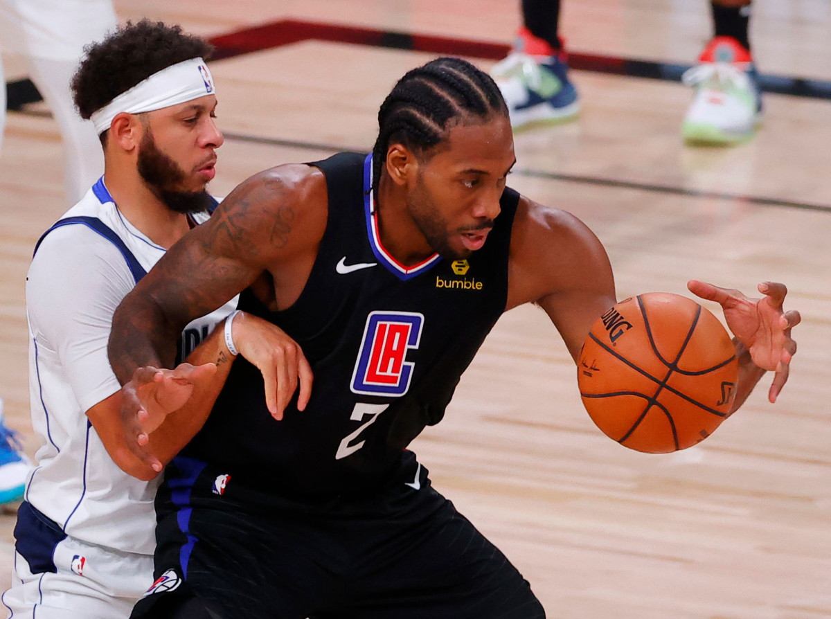 Clippers star Kawhi Leonard works against Dallas Mavericks guard Seth Curry.