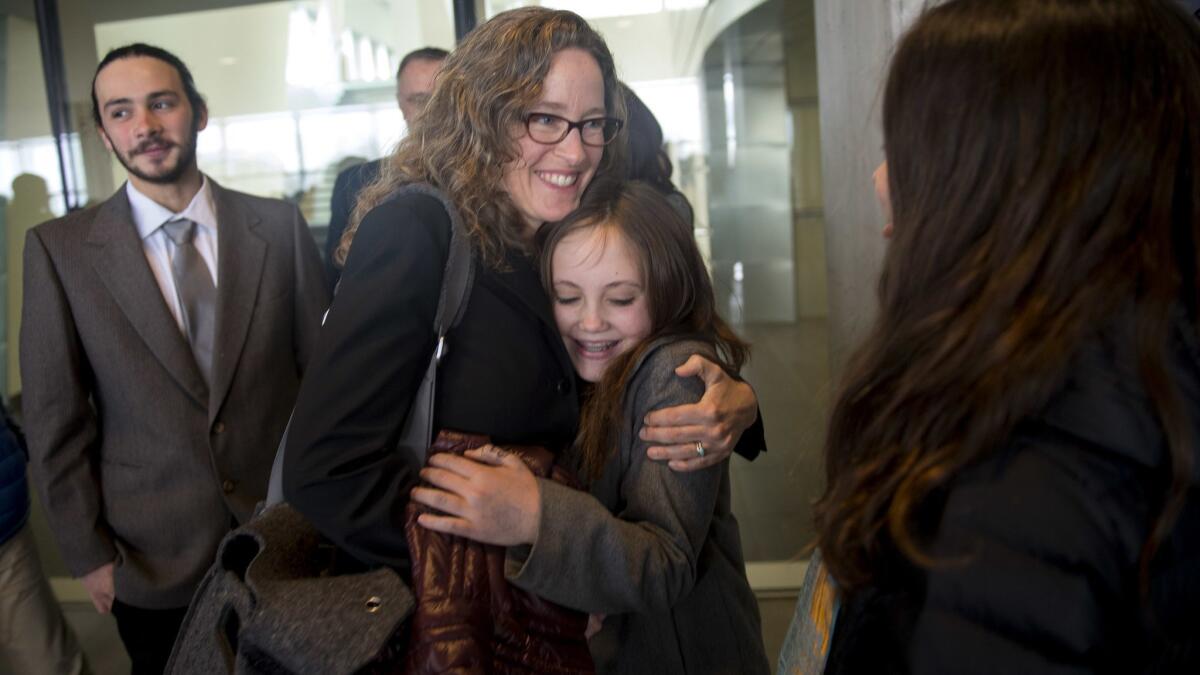 Attorney Julia Olson hugs one of the young plaintiffs outside the federal courthouse in Eugene, Ore.