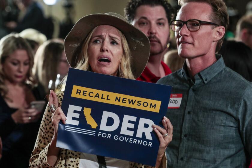 Costa Mesa, CA, Tuesday, September 14, 2021 - Kellie Avakian crosses her fingers but shows disappointment as poll results are broadcast showing a nearly 70 percent vote against the recall of Governor Newsom at a rally for candidate Larry Elder at the Orange County Hilton. (Robert Gauthier/Los Angeles Times)