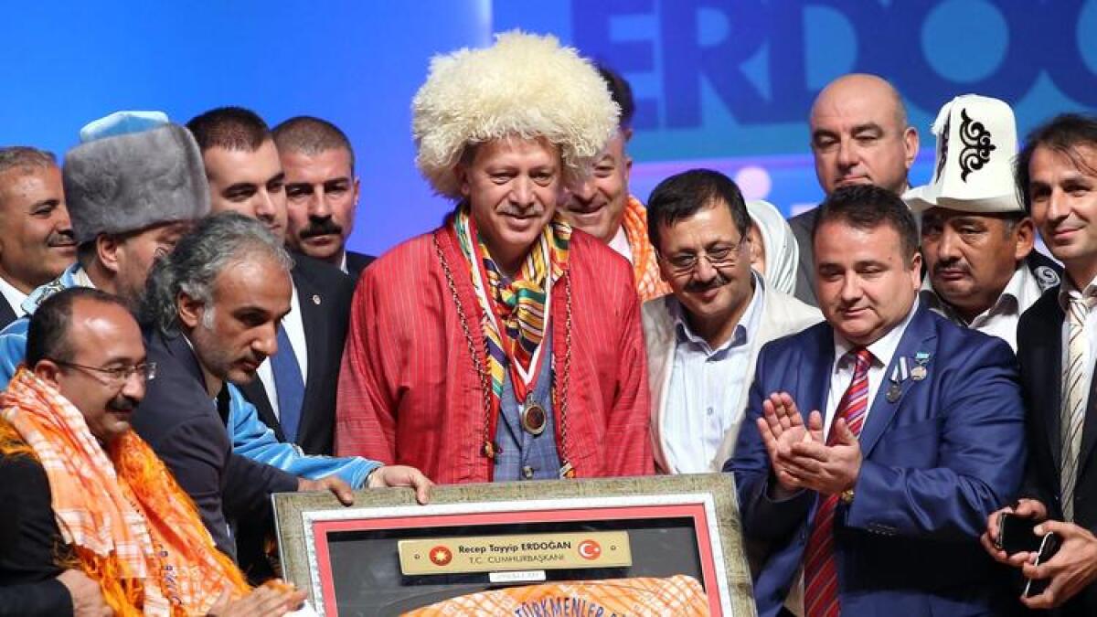 Recep Tayyip Erdogan, center, poses wearing traditional Turkmen clothes.