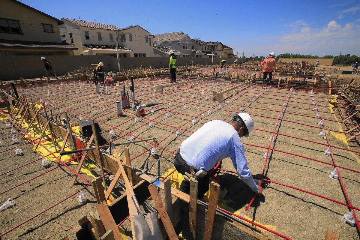 Construction workers prepare the foundation of a new home in Irvine on Aug. 19, 2014.