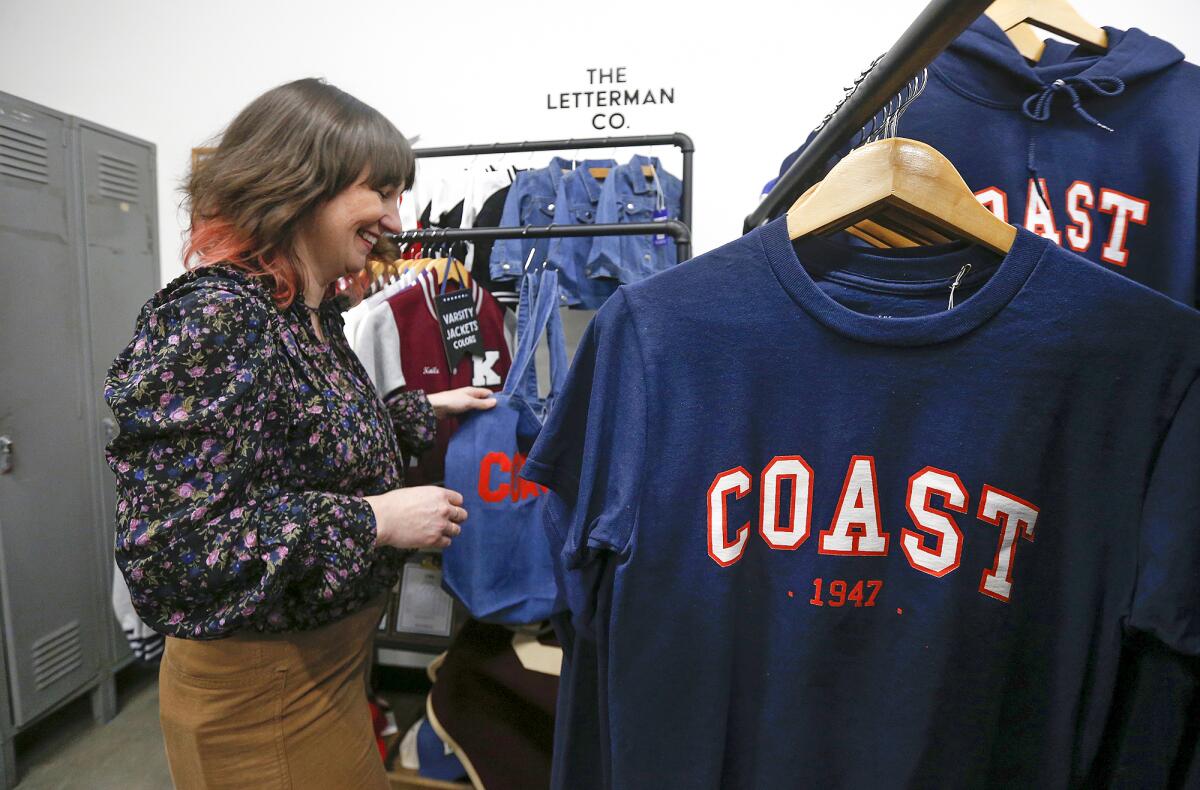 Laura Bonnell, shows off her varsity jackets, bags, and sweatshirts, during the grand opening of the Coast Collective Co-Lab.
