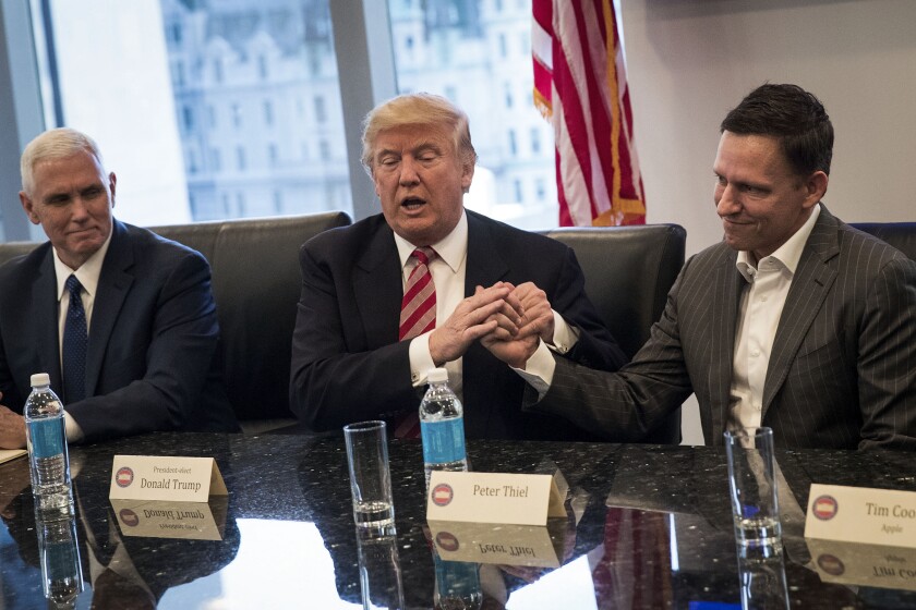 El vicepresidente Mike Pence, el presidente Donald Trump y Peter Thiel se sientan uno al lado del otro en una mesa