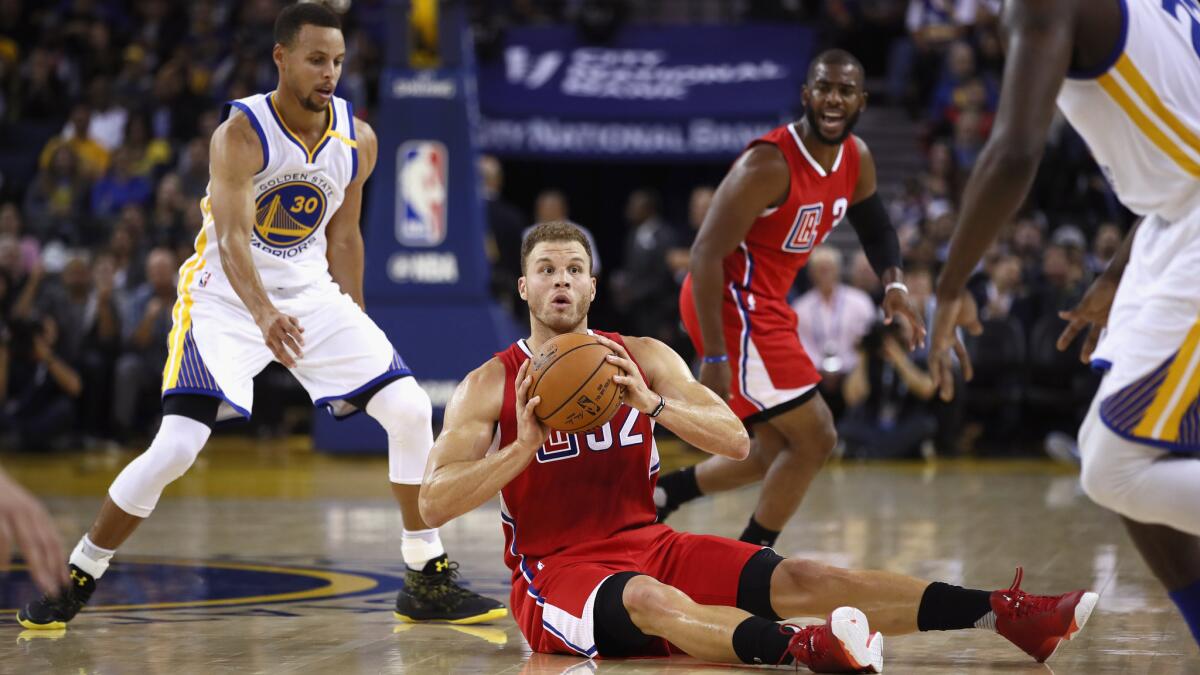 Blake Griffin tries to get rid of the ball as the Warriors' Stephen Curry, left, approaches during Tuesday night's game in Oakland.